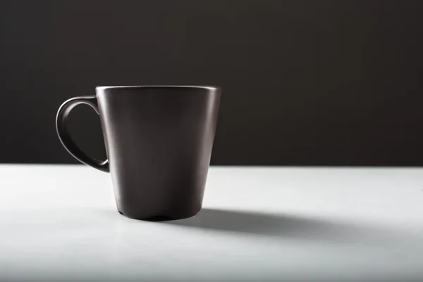 Schwarze Kaffeetasse auf dem weißen Tisch — Stockfoto