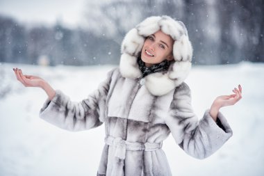 Woman have fun on the snow in winter forest clipart