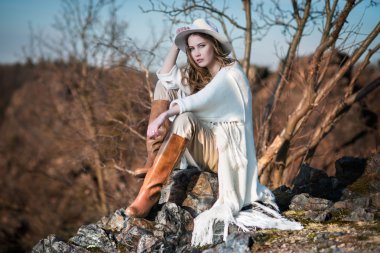 Ülke tarzı Kanyon kayaya oturan kadın moda