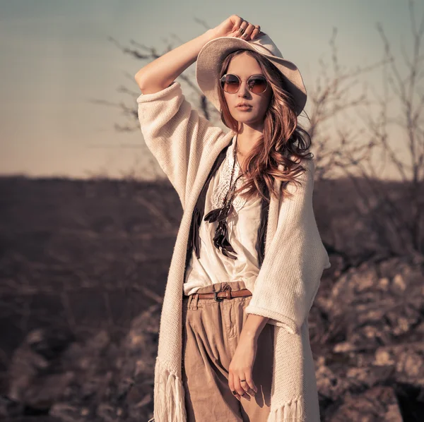 Vrouw in witte hoed en zonnebril poseren buitenshuis — Stockfoto