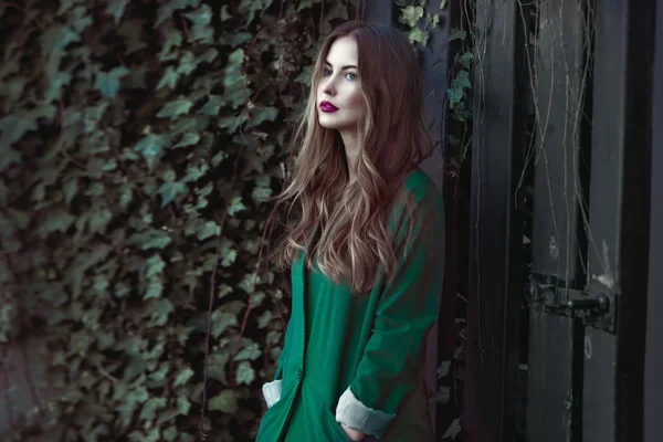 Femme de mode en manteau vert posant à l'extérieur — Photo
