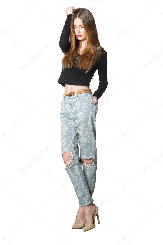 Pretty woman with bare belly in tight jeans on a white background