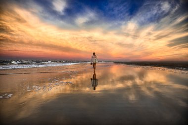 Okyanusu yakınlarındaki Sahilde yürüyüş ve gün batımında çekip genç kadın