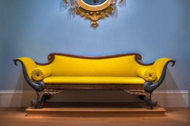 Luxury yellow sofa in front of the blue wall. clipart