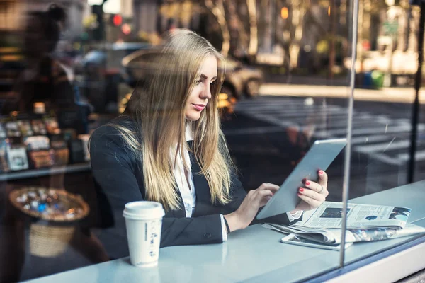 Femeie de afaceri care stă în cafenea și utilizează tabletă PC și bea cafea . — Fotografie, imagine de stoc