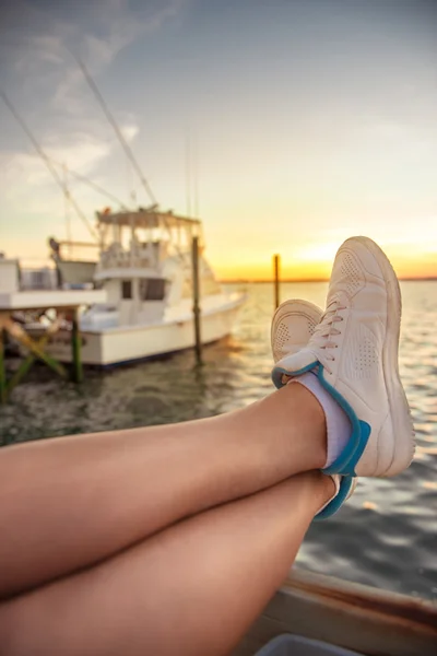 Frauenbeine entspannen auf der Jacht in der Meeresbucht — Stockfoto