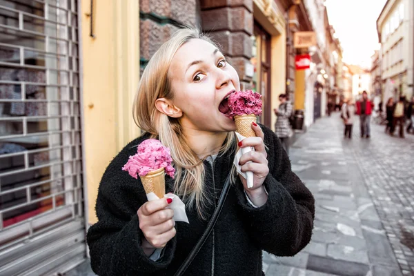 Funny woman eating ice cream cone in the city