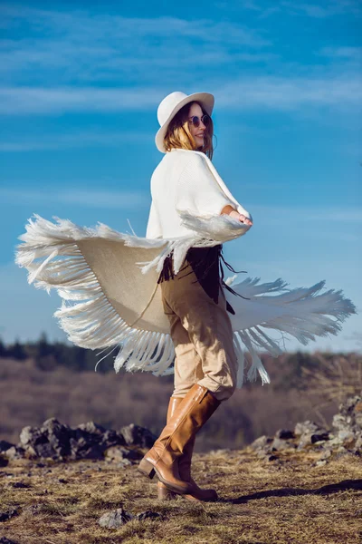 Mulher feliz país desfrutando da natureza em montanhas vestindo poncho, chapéu e óculos de sol — Fotografia de Stock