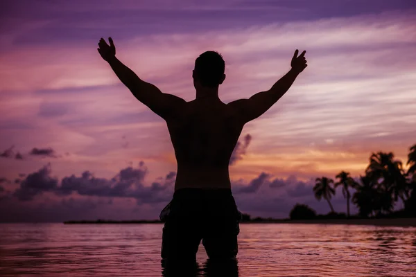 Silhouet van gelukkig man op vakantie plezier op het strand van het tropische eiland — Stockfoto