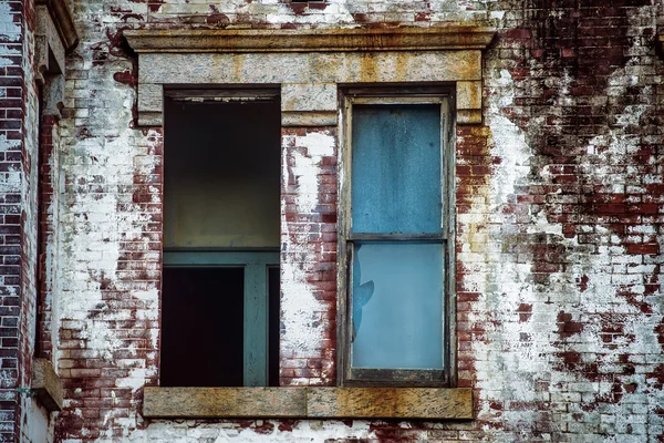 Janela quebrada em casa de tijolo caro abandonado — Fotografia de Stock