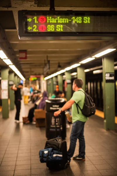 ニューヨーク市の地下鉄駅で地下鉄の列車を待っているバッグを持つパッサンガー — ストック写真