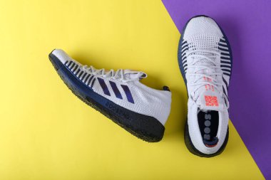 Jeddah Suudi Arabistan 26 Aralık 2020: Adidas Koşu Botları. Adidas, çok uluslu şirket. Sarı ve mor arka planda izole edilmiş. Ürün çekimleri