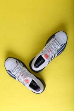 Jeddah Suudi Arabistan 26 Aralık 2020: Adidas Koşu Botları. Adidas, çok uluslu şirket. Sarı ve mor arka planda izole edilmiş. Ürün çekimleri