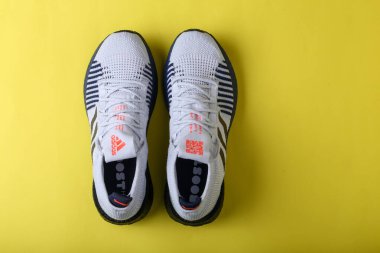 Jeddah Suudi Arabistan 26 Aralık 2020: Adidas Koşu Botları. Adidas, çok uluslu şirket. Sarı ve mor arka planda izole edilmiş. Ürün çekimleri