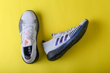 Jeddah Suudi Arabistan 26 Aralık 2020: Adidas Koşu Botları. Adidas, çok uluslu şirket. Sarı ve mor arka planda izole edilmiş. Ürün çekimleri