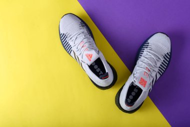 Jeddah Suudi Arabistan 26 Aralık 2020: Adidas Koşu Botları. Adidas, çok uluslu şirket. Sarı ve mor arka planda izole edilmiş. Ürün çekimleri