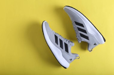 Jeddah Suudi Arabistan 26 Aralık 2020: Gri Adidas Koşu Ayakkabıları. Adidas, çok uluslu şirket. Siyah ve Sarı arka planda izole edilmiş. Ürün çekimleri
