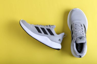 Jeddah Suudi Arabistan 26 Aralık 2020: Gri Adidas Koşu Ayakkabıları. Adidas, çok uluslu şirket. Siyah ve Sarı arka planda izole edilmiş. Ürün çekimleri