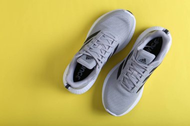 Jeddah Suudi Arabistan 26 Aralık 2020: Gri Adidas Koşu Ayakkabıları. Adidas, çok uluslu şirket. Siyah ve Sarı arka planda izole edilmiş. Ürün çekimleri