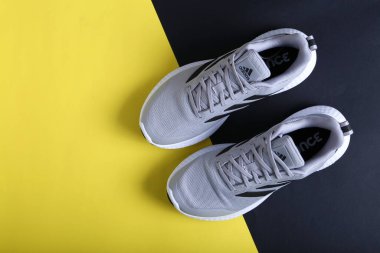 Jeddah Suudi Arabistan 26 Aralık 2020: Gri Adidas Koşu Ayakkabıları. Adidas, çok uluslu şirket. Siyah ve Sarı arka planda izole edilmiş. Ürün çekimleri
