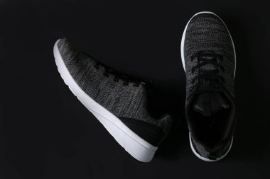 Gri koşu botlarının üst görüntüsü. Sağ tarafta kopyalama alanı olan yeşil ve siyah arka planlı spor ayakkabıları