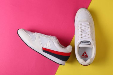 Jeddah Suudi Arabistan 17 Şubat 2021 White le coq spor koşu ayakkabıları. le coq spor ayakkabılar. Pembe ve sarı arka planda izole edilmiş. Ürün çekimleri