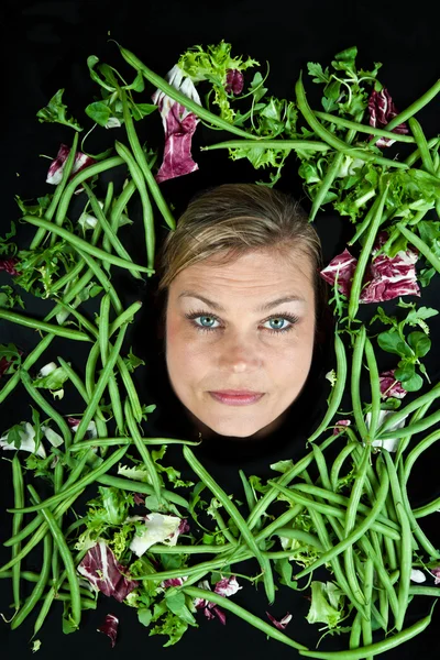 Femme blonde avec des légumes autour de la tête — Photo