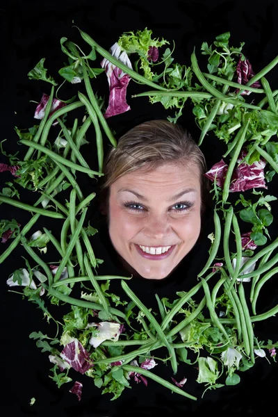 Blond kvinna med grönsaker aroound huvudet — Stockfoto