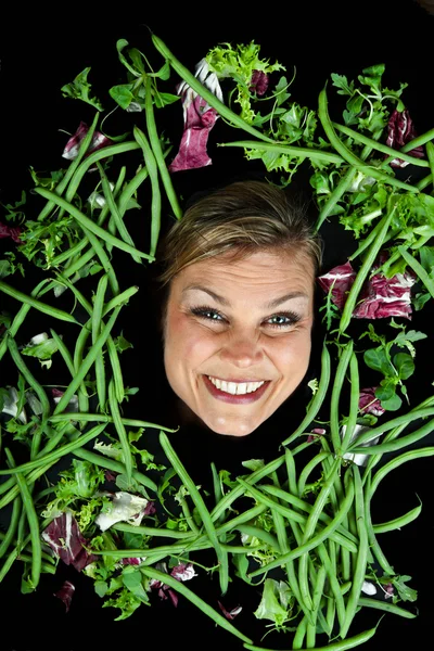 Blond kvinna med grönsaker aroound huvudet — Stockfoto