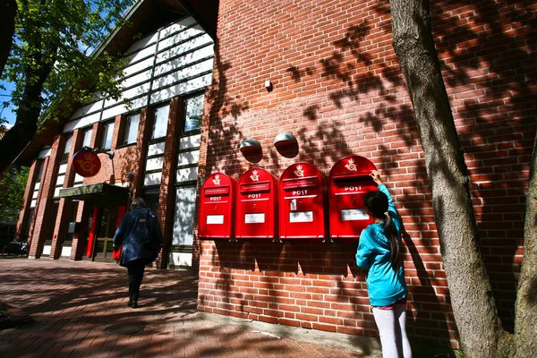 Girl dropping a letter in postbox — Stock Photo, Image