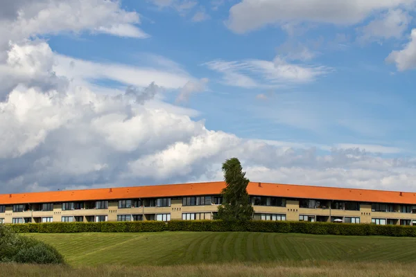 Huis met weide onder bewolkte hemel — Stockfoto