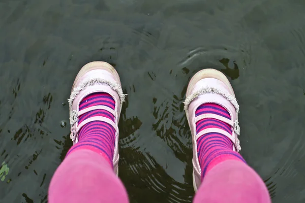 Roze benen van een kind zit — Stockfoto