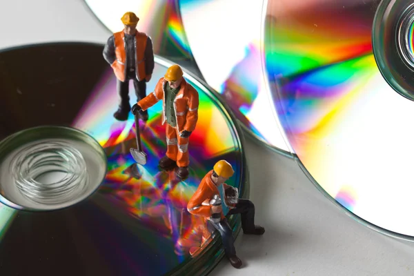 Miniaturearbejdere med cd 'er - Stock-foto