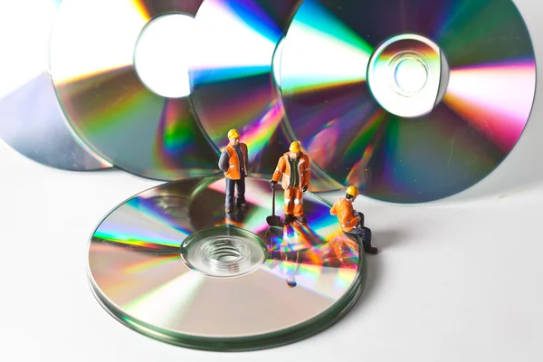 Trabalhadores em miniatura com CDs — Fotografia de Stock