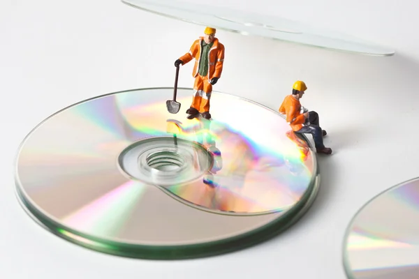 Мініатюрні працівники з компакт-дисків — стокове фото