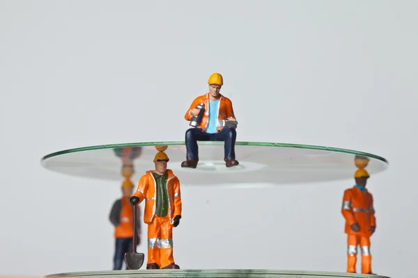 Trabalhadores em miniatura com CDs — Fotografia de Stock