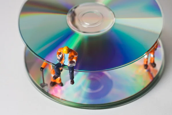 Miniature workers with CDs — Stock Photo, Image