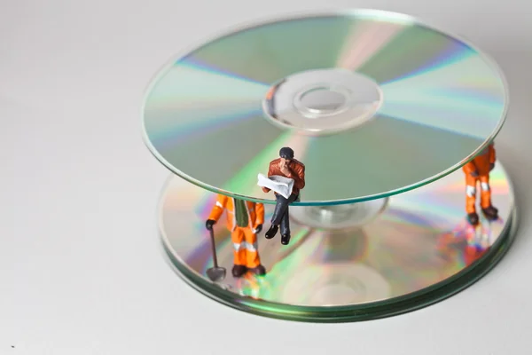 Miniature workers with CDs — Stock Photo, Image