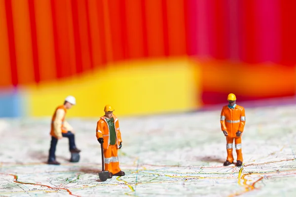 Trabajadores en miniatura en acción en una hoja de ruta — Foto de Stock