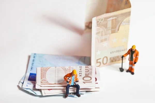 Trabalhadores em miniatura com notas de euro — Fotografia de Stock