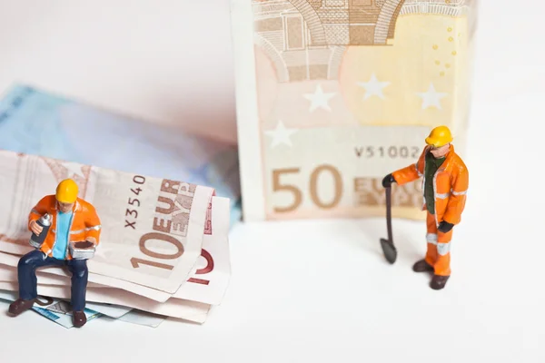 Trabalhadores em miniatura com notas de euro — Fotografia de Stock