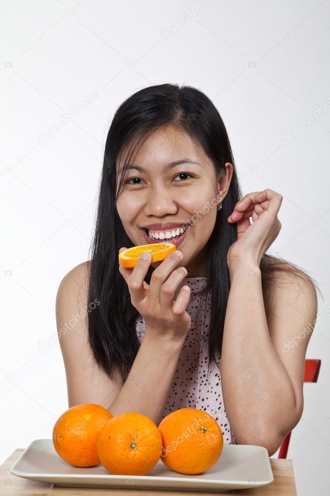 Asian girl with a plate of oranges