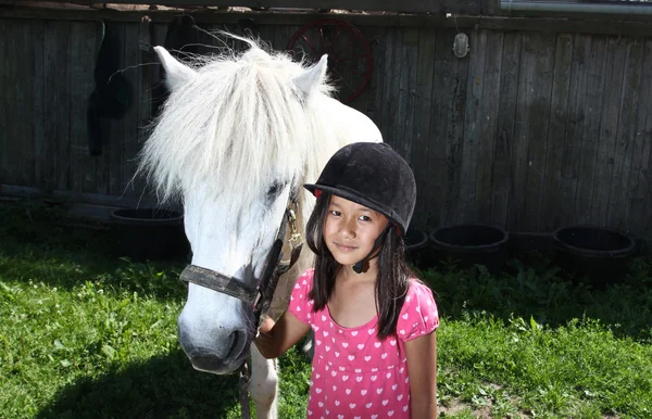 Chica librando a un caballo blanco — Foto de Stock