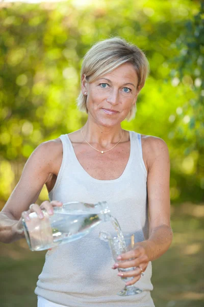 Bir bardak su dökme kadın — Stok fotoğraf