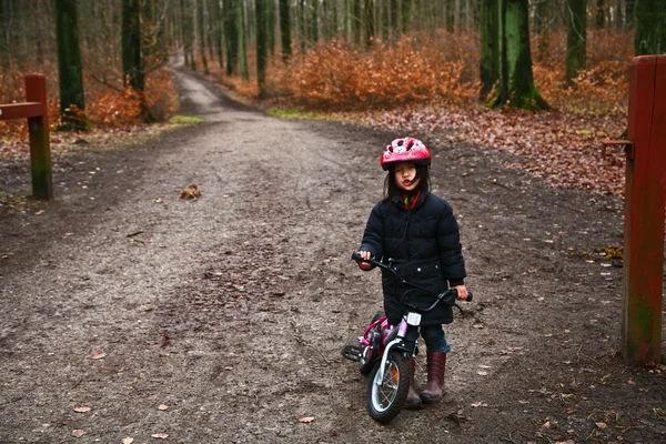 Dziecko w lesie na rowerze — Zdjęcie stockowe