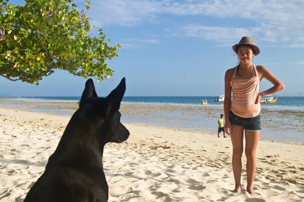 Hond en meisje op het strand — Stockfoto