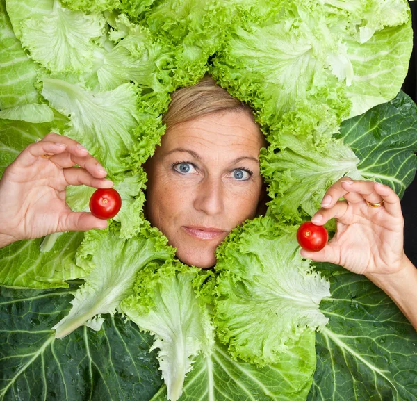 Femme avec des feuilles de salade disposées autour de son visage — Photo