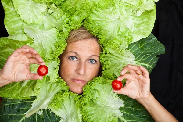 Vrouw met salade verlaat gearrangeerde rond haar gezicht — Stockfoto