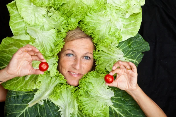 Femme avec des feuilles de salade disposées autour de son visage — Photo