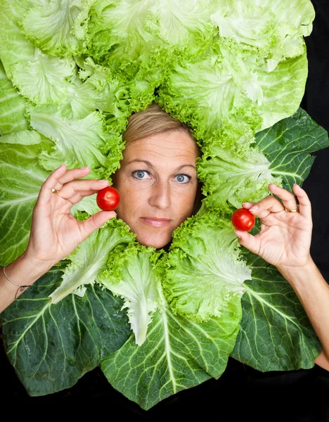 Mulher com folhas de salada dispostas em torno de seu rosto — Fotografia de Stock